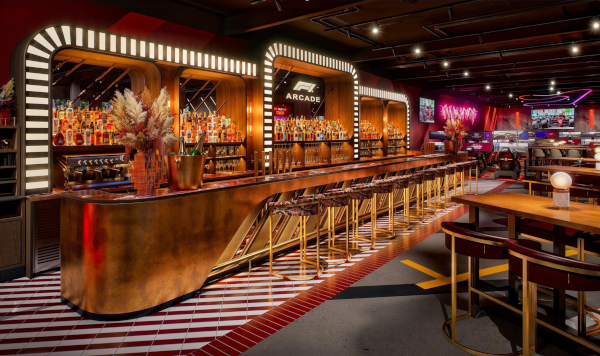 Bar central F1 Arcade Madrid, comptoir cuivré de 12 mètres, ambiance racing et gastronomie intégrée